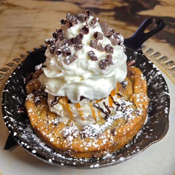Skillet dessert topped with whipped cream at Crave Café