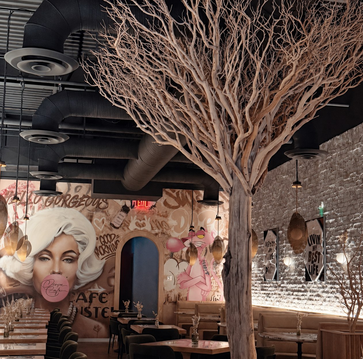 The sculptural tree, mural wall and dining room seating at Crave Café